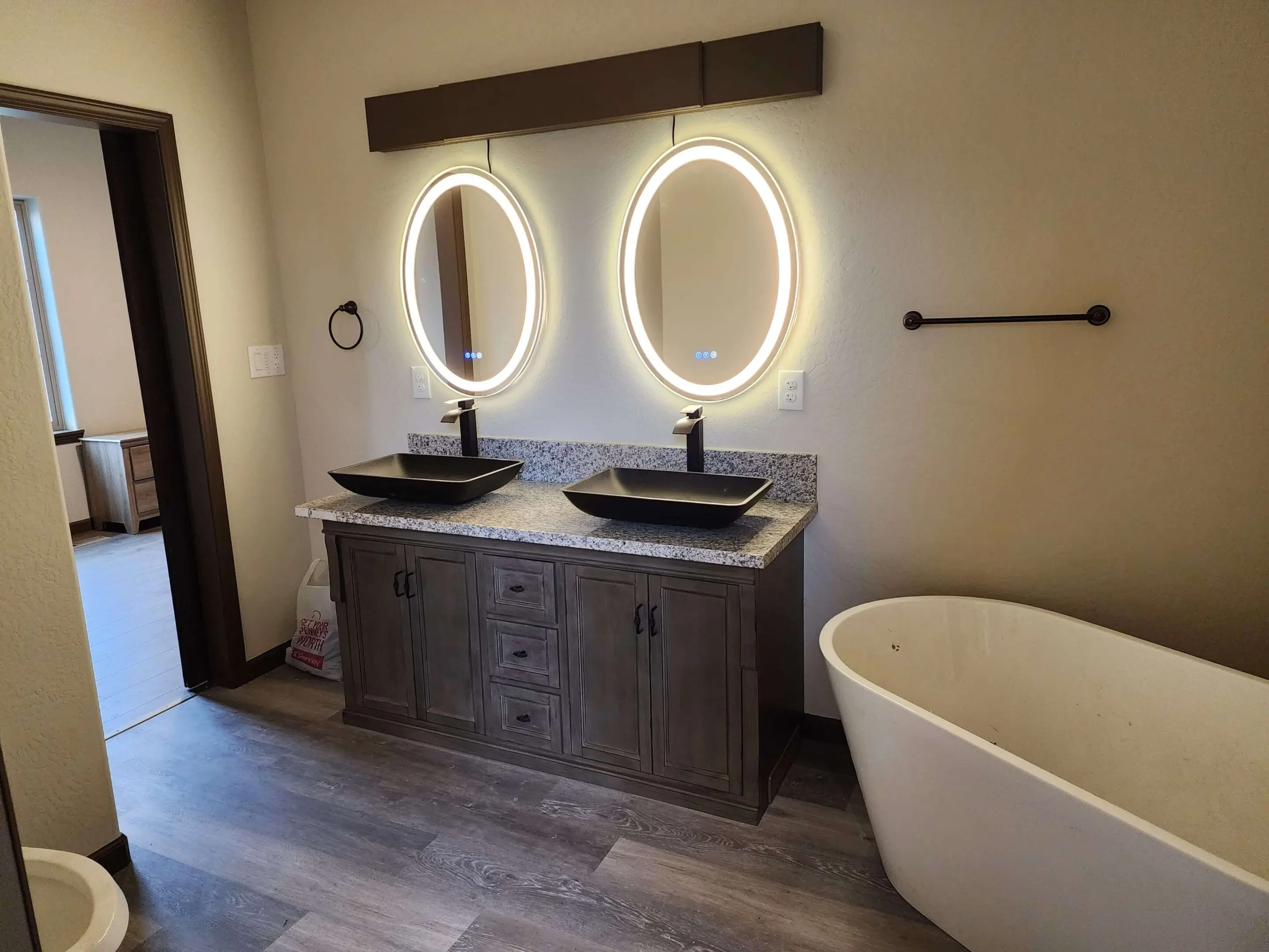 Modern bathroom with double vanity and tub.
