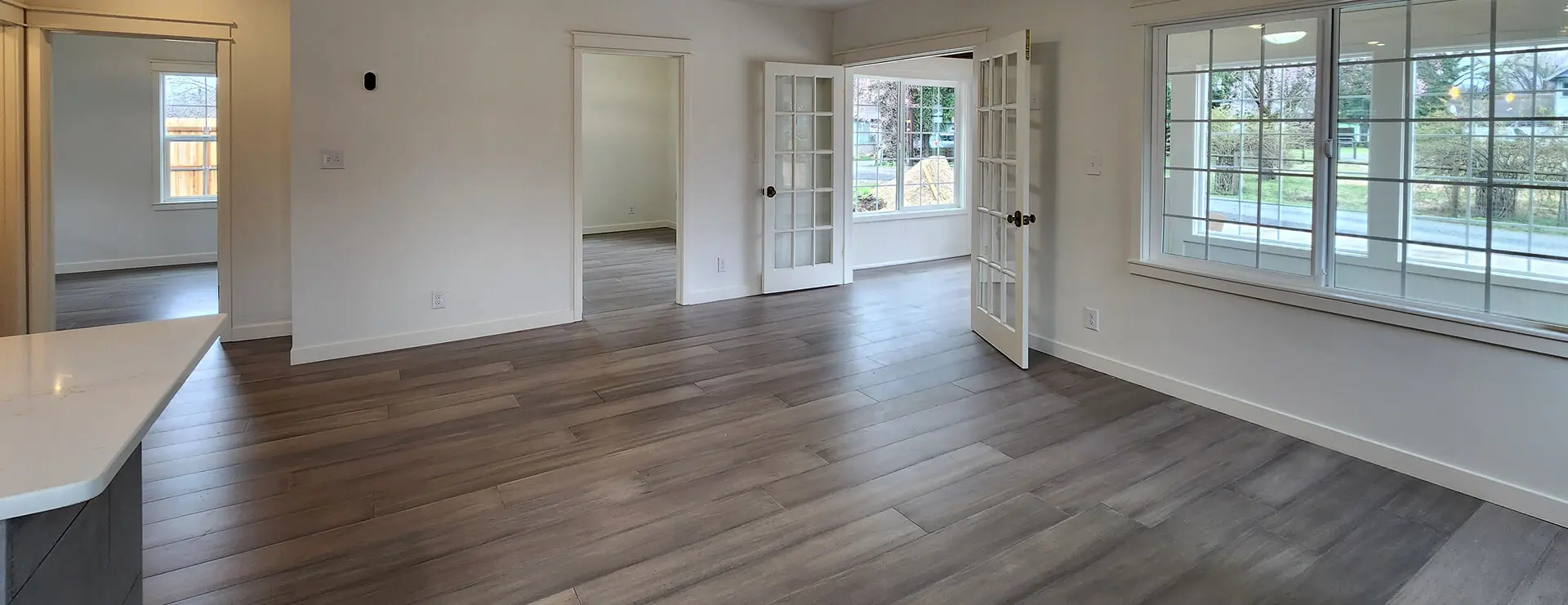Empty room with wooden floor and windows.