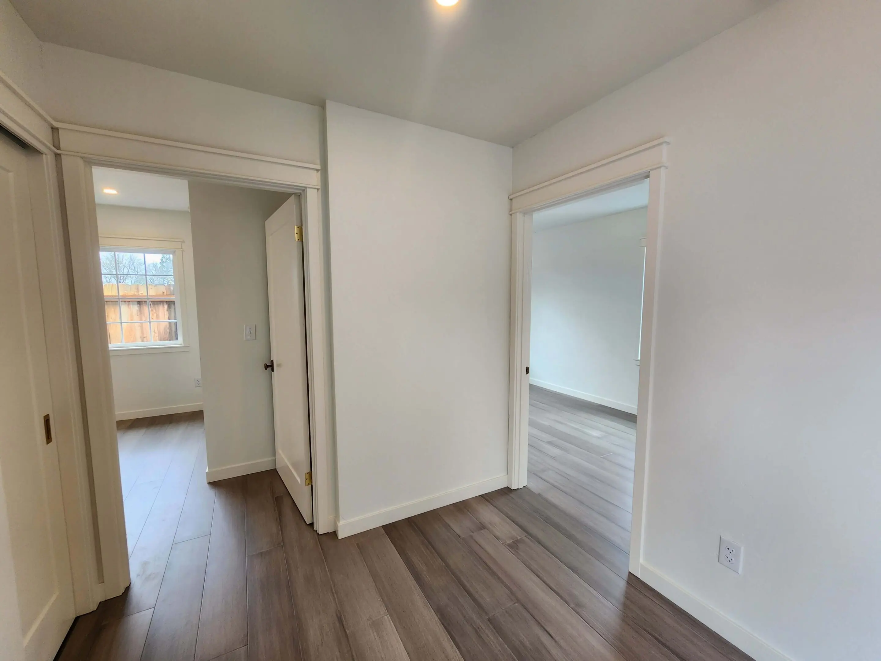 Hallway with wooden floor and white walls.