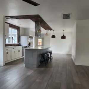 Modern kitchen with island and wooden flooring.