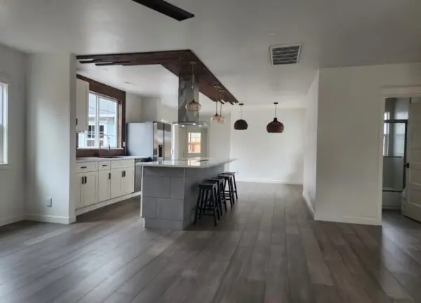 Modern kitchen with island and wooden flooring.
