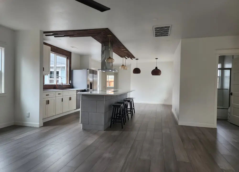 Modern kitchen with island and wooden flooring.